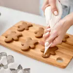 una mujer decorando galletas de jengibre 