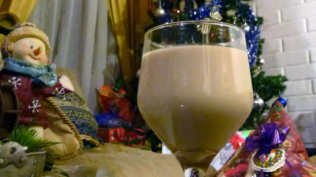 una copa de colemono junto a un árbol de navidad y regalos